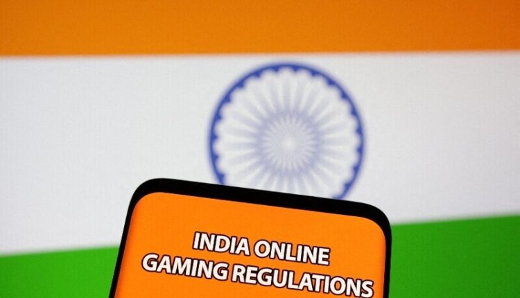Smartphone showing a game app next to the Indian flag representing the new online gaming ban.
