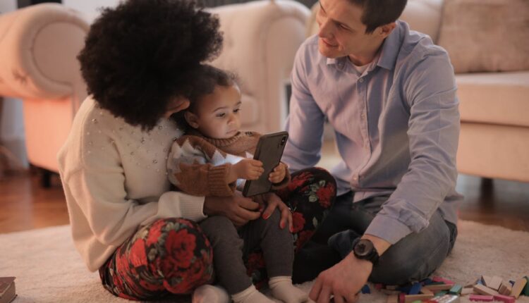 Child watching tablet screen in dark room, symbolizing health risks from excessive screen time.