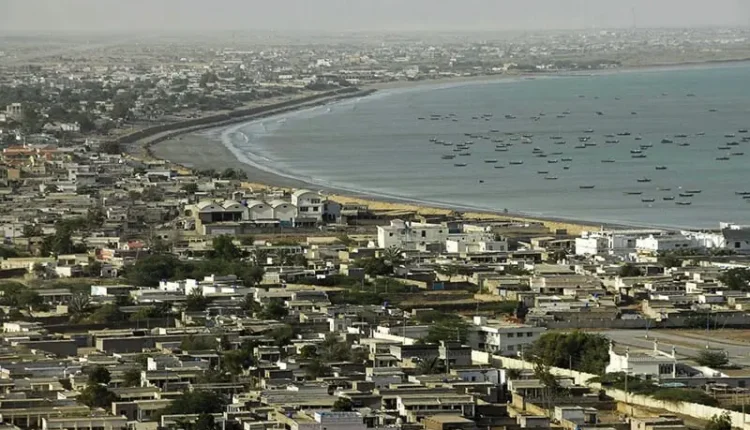 Aerial view of Gwadar Port with solar panels on terminal roofs under a bright sun.