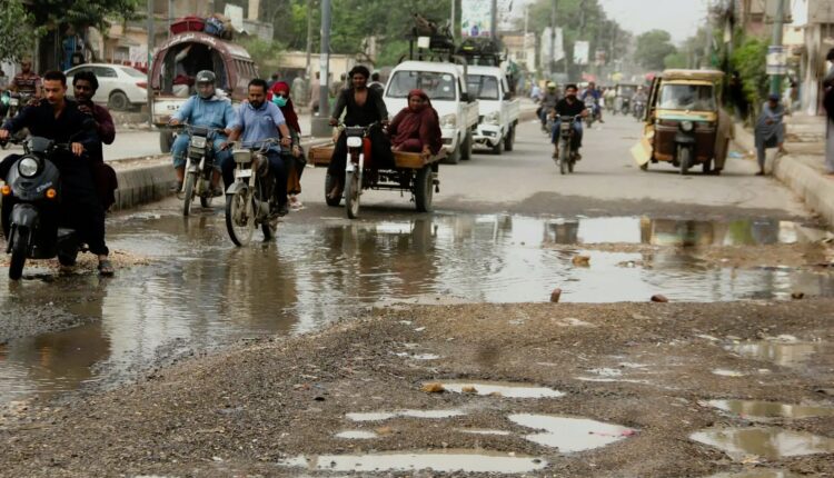 Karachi traffic jams on flood-hit roads during repair and drainage work after heavy rains.