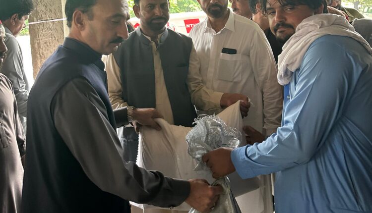 Relief workers distributing food ration bags to flood-affected families in Islamabad.