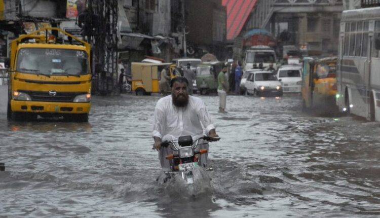 Army and rescue workers using boats to help families evacuate a flooded village in Punjab.