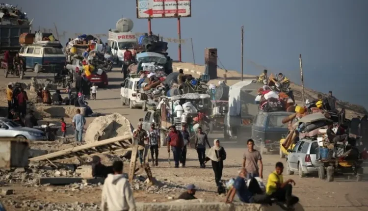 A long line of Palestinians fleeing Gaza City on foot and with donkey carts, carrying their belongings.
